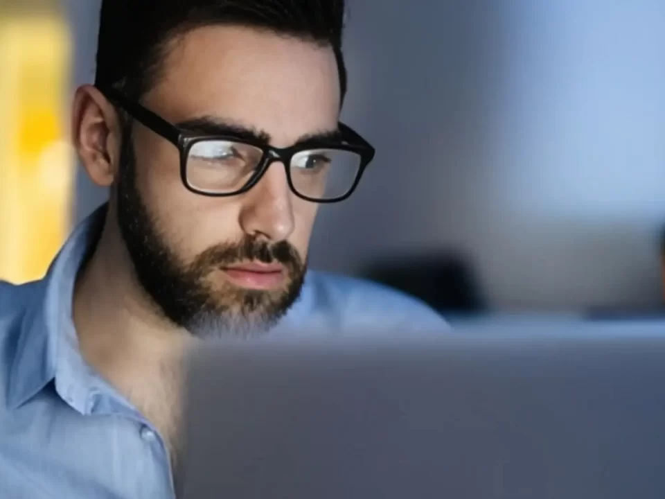 Persona frente al ordenador utilizando gafas de luz azul